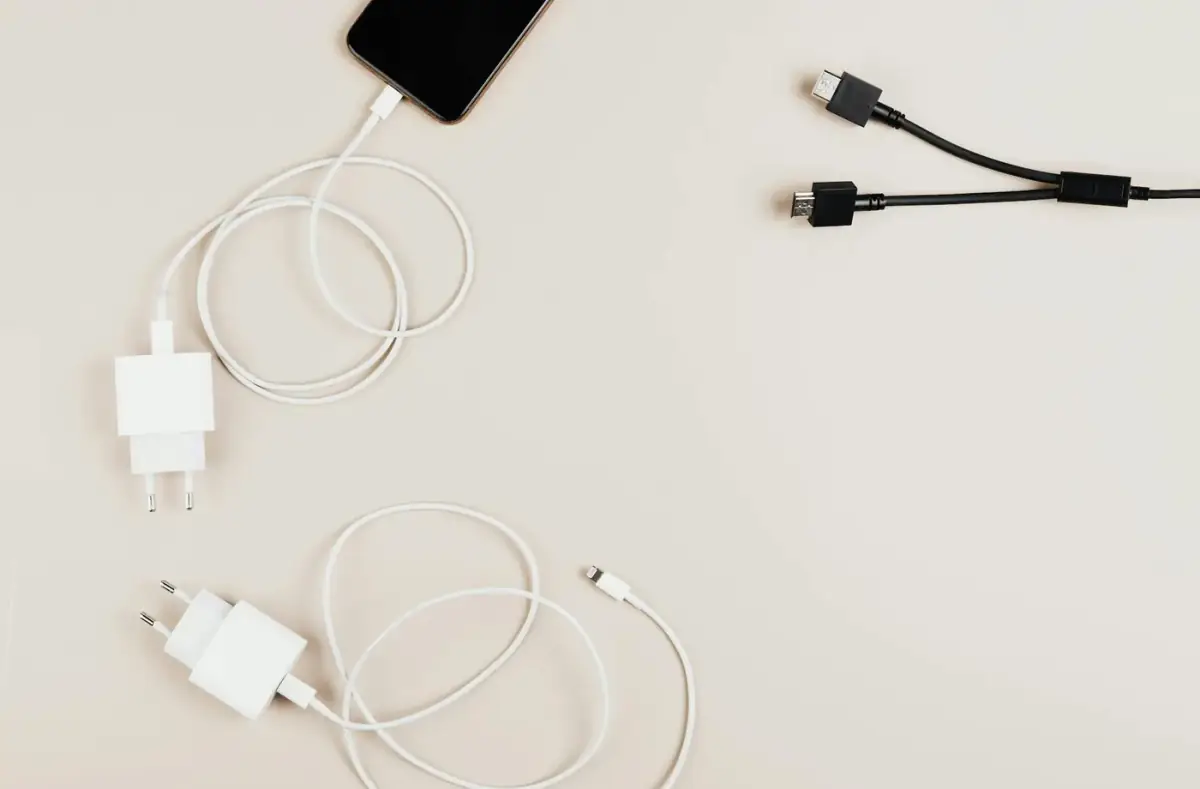 Laptop Not Charging When Plugged In: Safe Fixes: Charging cables and adapters arranged on a desk
