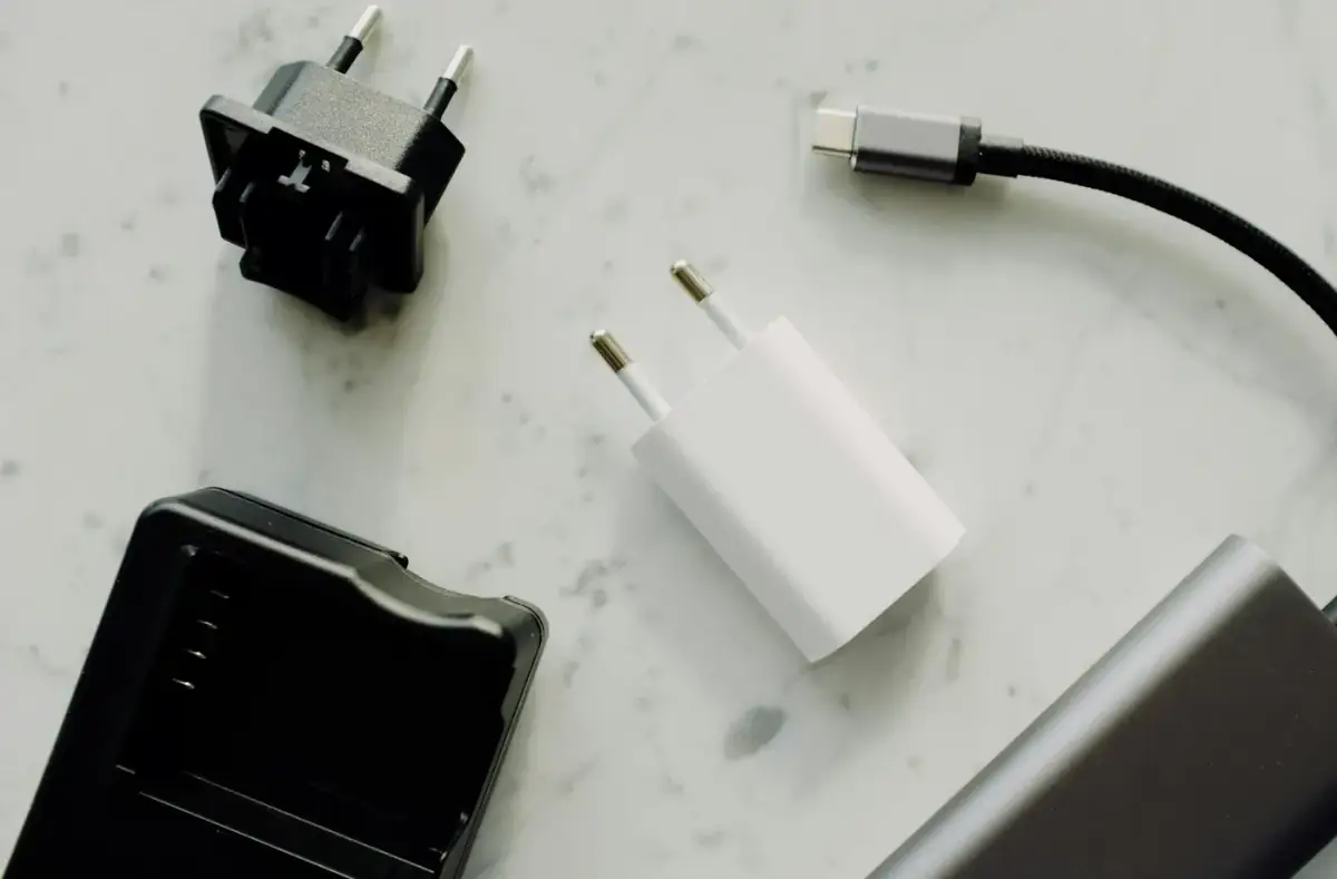 iPhone: USB-C charger, cable, and phone charging setup on a desk